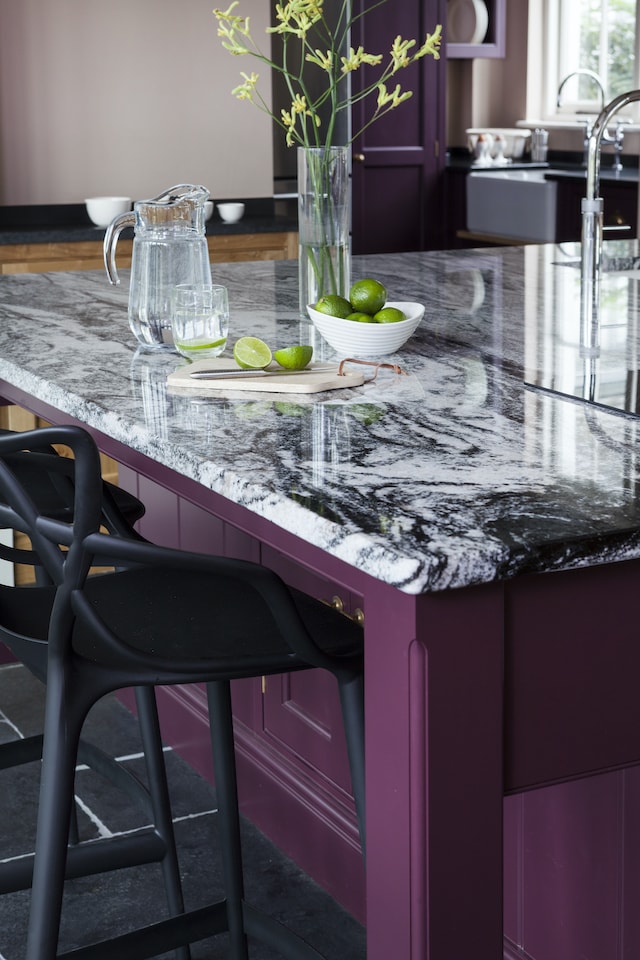 striking black and white marble worktop with purple cabinets in luxury kitchen